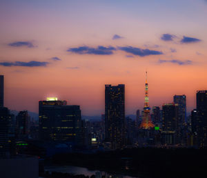 Illuminated buildings against sky during sunset