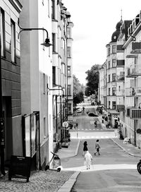 People walking on street amidst buildings in city