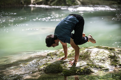 Side view of man sitting on rock