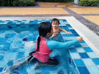 Siblings swimming in pool