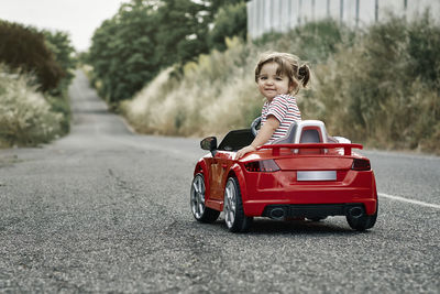 A girl riding a toy car