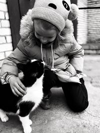 Rear view of girl sitting with cat