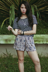 Portrait of young woman smoking cigarette