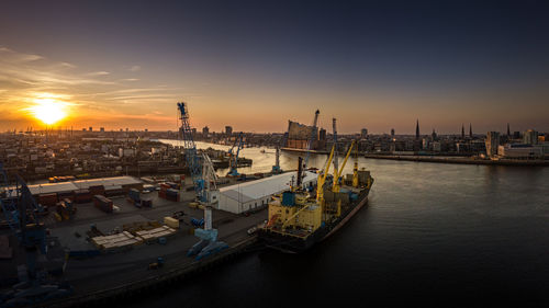 The elbe philharmonic hall in the port of hamburg at sunset with container ship in the foreground