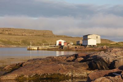 Scenic view of sea by buildings against sky