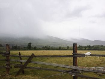 Fence on field against sky