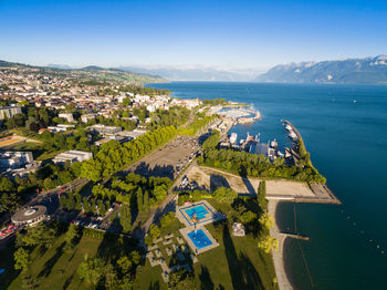 Aerial view of city by sea against sky