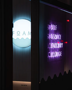 Close-up of illuminated text on glass window