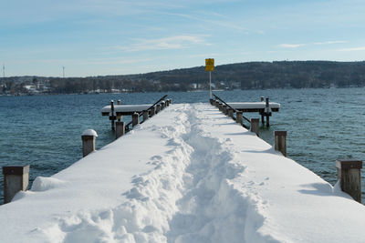 Pier over lake against sky during winter