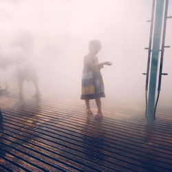 Full length of woman walking on illuminated bridge