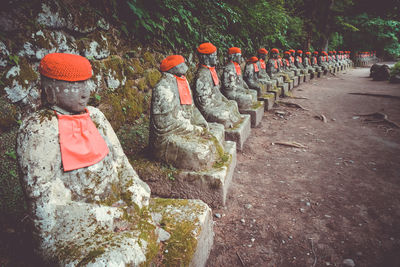 Statues on rock against trees