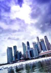 Buildings in city against cloudy sky