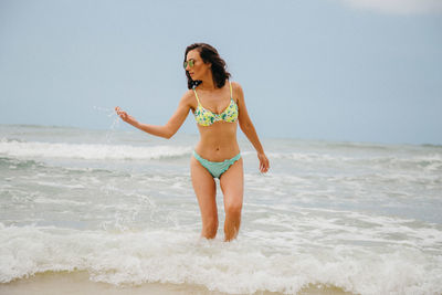 Full length of young woman standing on beach