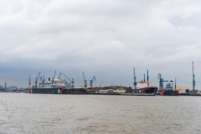 Commercial dock by sea against sky