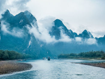 Scenic view of sea and mountains against sky