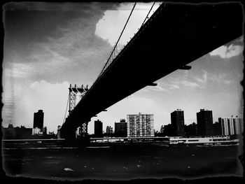 Bridge over river against cloudy sky
