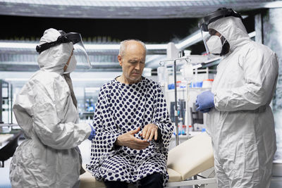 Rear view of female friends standing in hospital