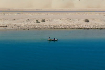 People on boat in sea against sky