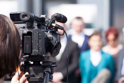 Woman filming people through television camera