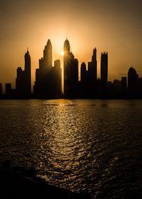 Silhouette of buildings against sky during sunset