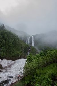 Scenic view of waterfall against sky