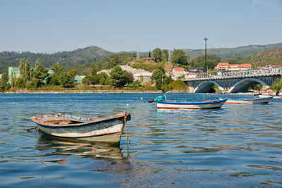 Boats moored in river against clear sky