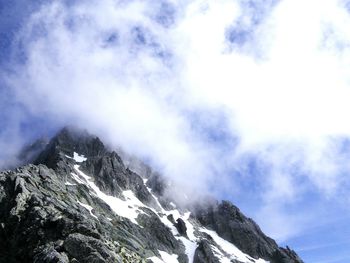 Scenic view of mountain range against cloudy sky