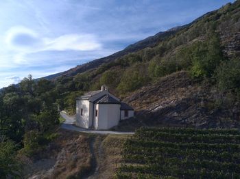 Built structure on land by mountain against sky