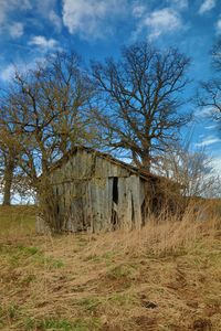 Abandoned house on field against sky