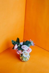 Close-up of flower bouquet against orange wall