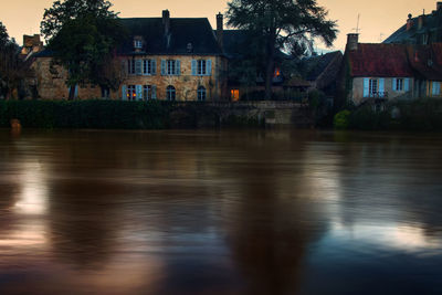 River flowing by houses during sunset