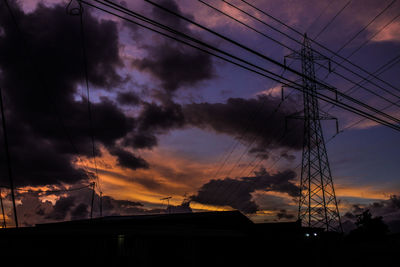 Low angle view of silhouette trees against dramatic sky