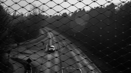 Full frame shot of chainlink fence against highway