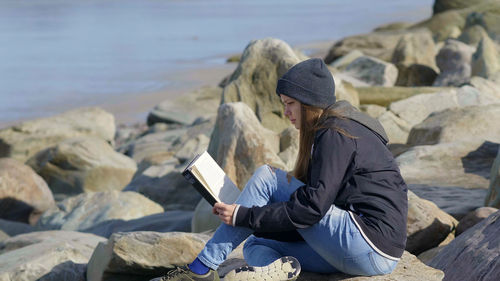 Woman sitting on rock at beach