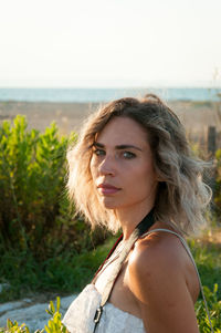 Portrait of beautiful young woman lying on land