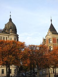 Trees and buildings against sky during autumn