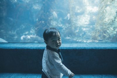 Portrait of boy standing at aquarium