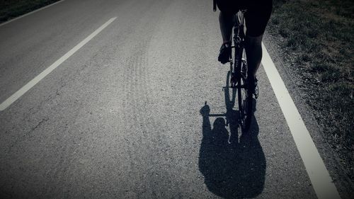 Low section of person riding bicycle on road