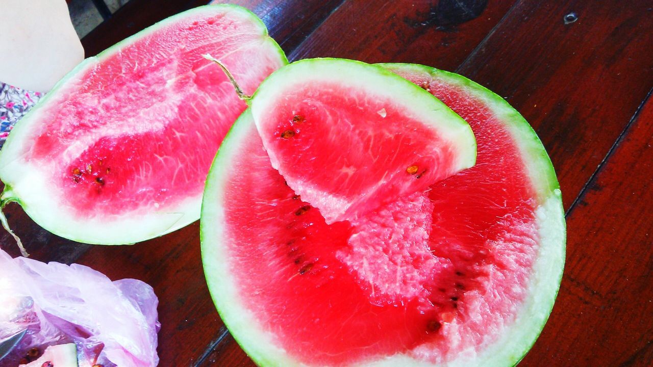 food and drink, food, freshness, healthy eating, fruit, indoors, still life, close-up, red, slice, table, high angle view, juicy, organic, no people, cross section, ripe, healthy lifestyle, halved, directly above