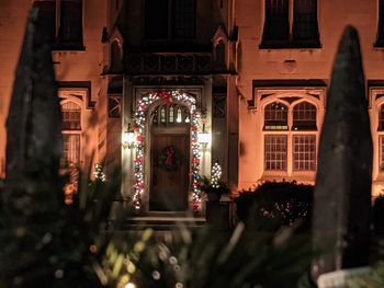 Christmas church cheer and lights at night through the iron gate.