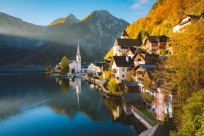 Residential district by lake against sky