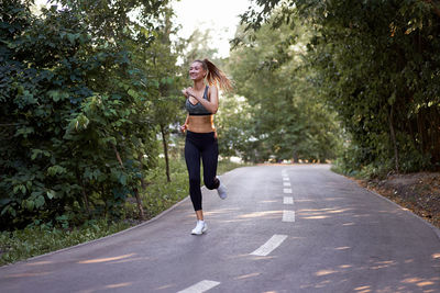 Full length of woman running on road