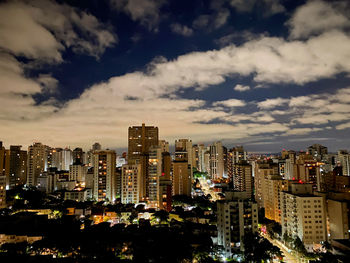 Illuminated buildings in city against sky