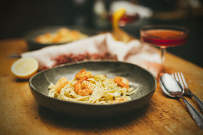 Homemade pasta with shrimp in citrus sauce on grey pottery