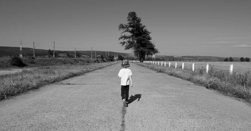 Rear view of man walking on road