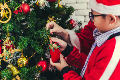 Midsection of man holding christmas tree