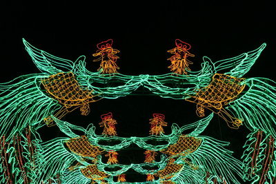 Close-up of illuminated lighting equipment against black background