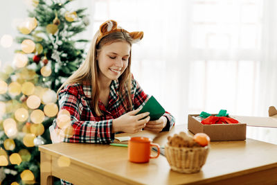 A cute teenage girl puts a letter with wishes for christmas or new year in an envelope