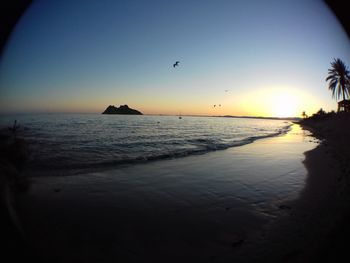 Scenic view of sea against clear sky during sunset