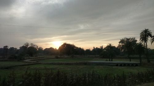 Scenic view of field against cloudy sky